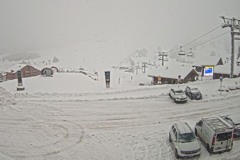 Lots of fresh snow covering the vehicles in the car park, ski lift and ski slopes in Les Saisies, France on 24 November 2025 – Weather to ski – Today in the Alps, 24 November 2025