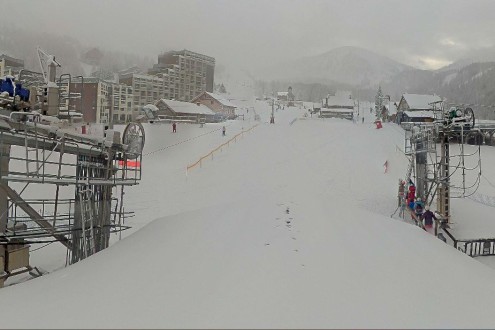 Lots of snow on the pistes in Isola 2000, with resort buildings and ski lifts pictured – Weather to ski – Today in the Alps, 24 December 2025