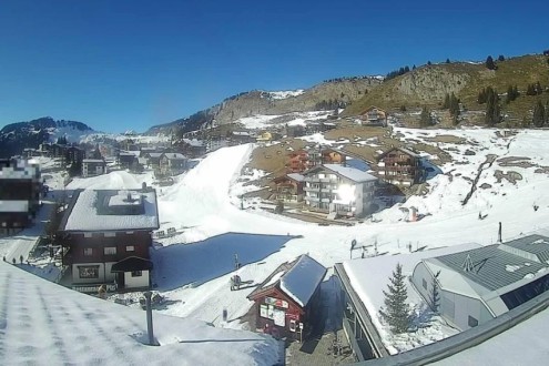 Blue skies above the buildings and mountainside in Riederalp in the Aletsch Arena, Switzerland – Weather to ski – Today in the Alps, 5 January 2026