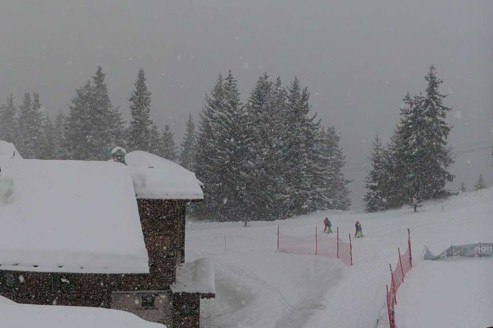 Heavy snow falling over the snow-topped buildings and trees on the mountainside in La Rosière, France – Link to Weather to ski's full Weather & Snow Forecast, 8 January 2026