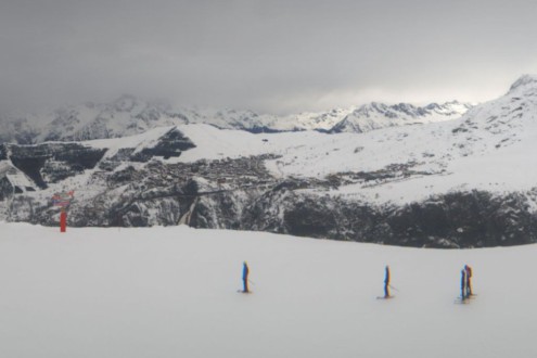 Cloudy skies over the ski slopes and skiers in Alpe d’Huez, France – Link to Weather to ski's full "Today in the Alps" report on weather and snow in the Alps on 27 January 2026
