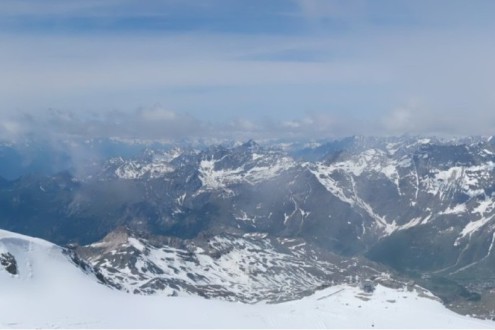 Moderately cloudy skies viewed from the Klein Matterhorn ski, looking over Zermatt’s summer ski area – Link to Weather to ski's report on Today in the Alps, 1 June 2026