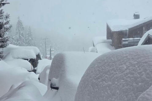 Very deep snow on the ground, trees, parked cars and rooftops in La Rosière, France – Weather to ski – Who got the most snow in the Alps in 2025-26?