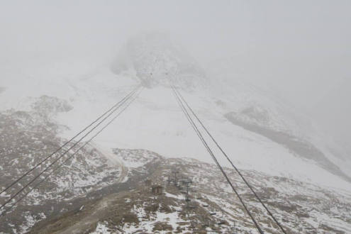 Light snow falling at high-altitude in Tignes, France, above the cable-car lines above the ski slopes of the Grande Motte glacier, on 20 October 2026 - Link to Weather to ski's report on Today in the Alps, 20 October 2026